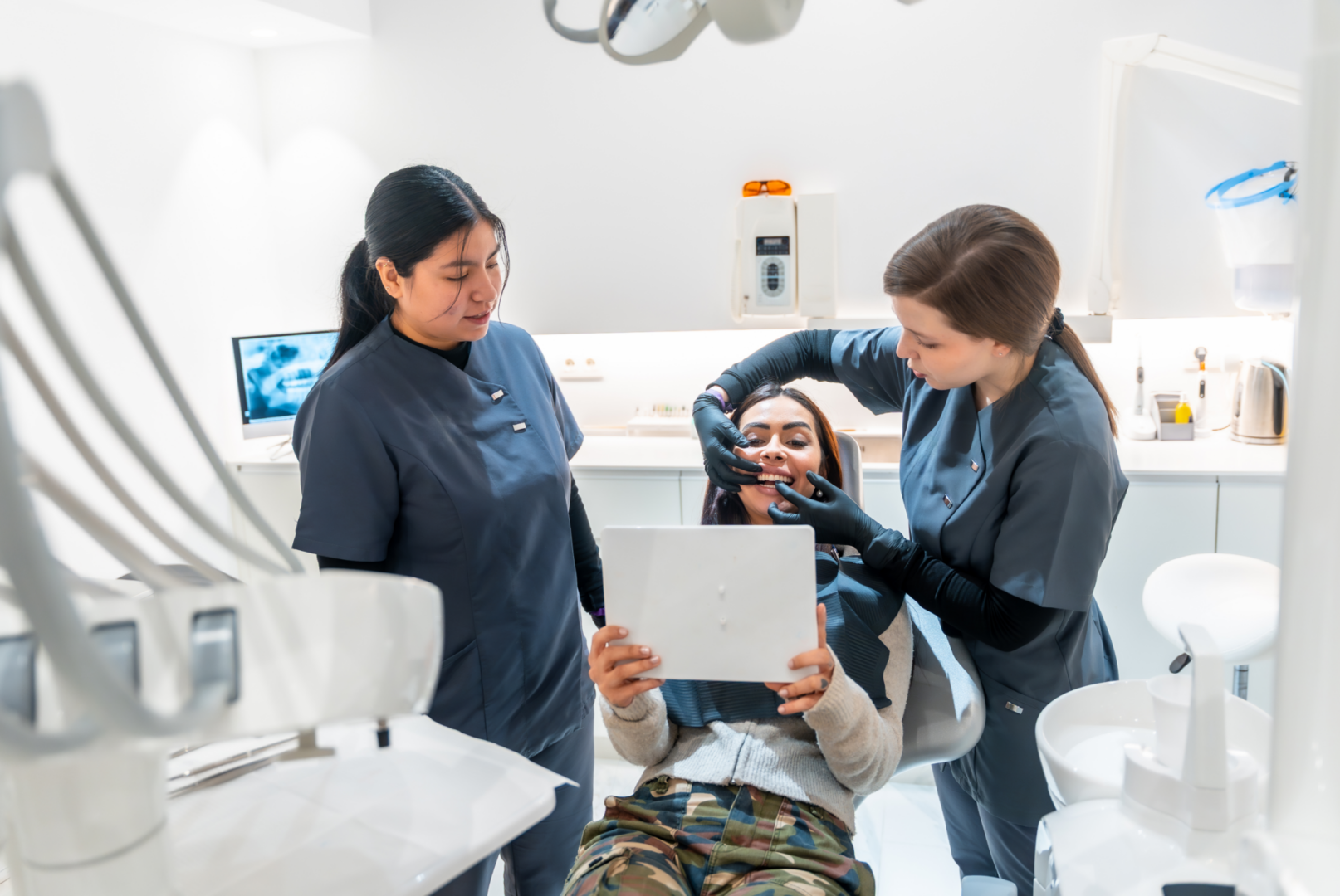 Dentists examining patient's teeth with mirror