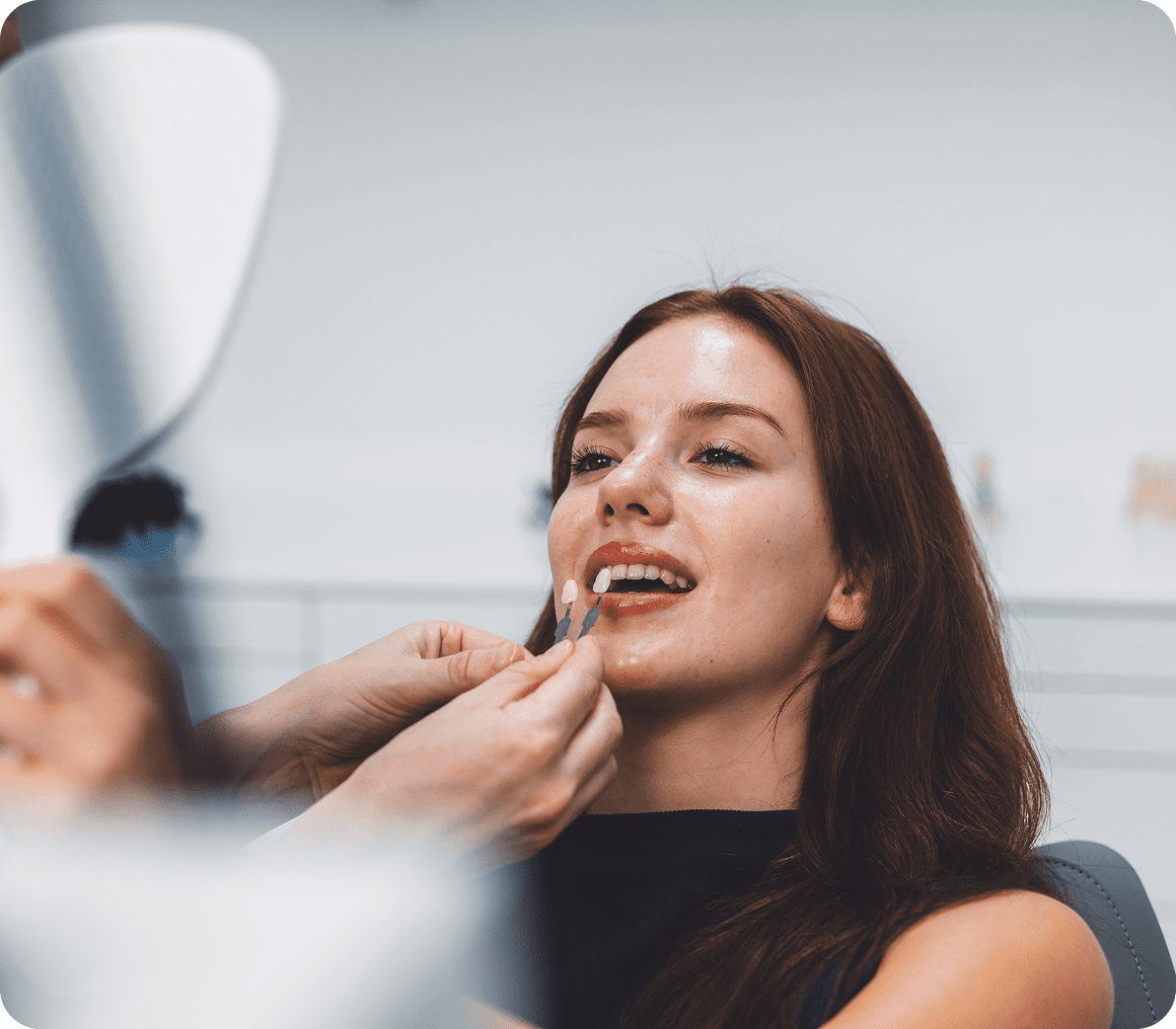 Makeup artist applying lipstick to smiling woman